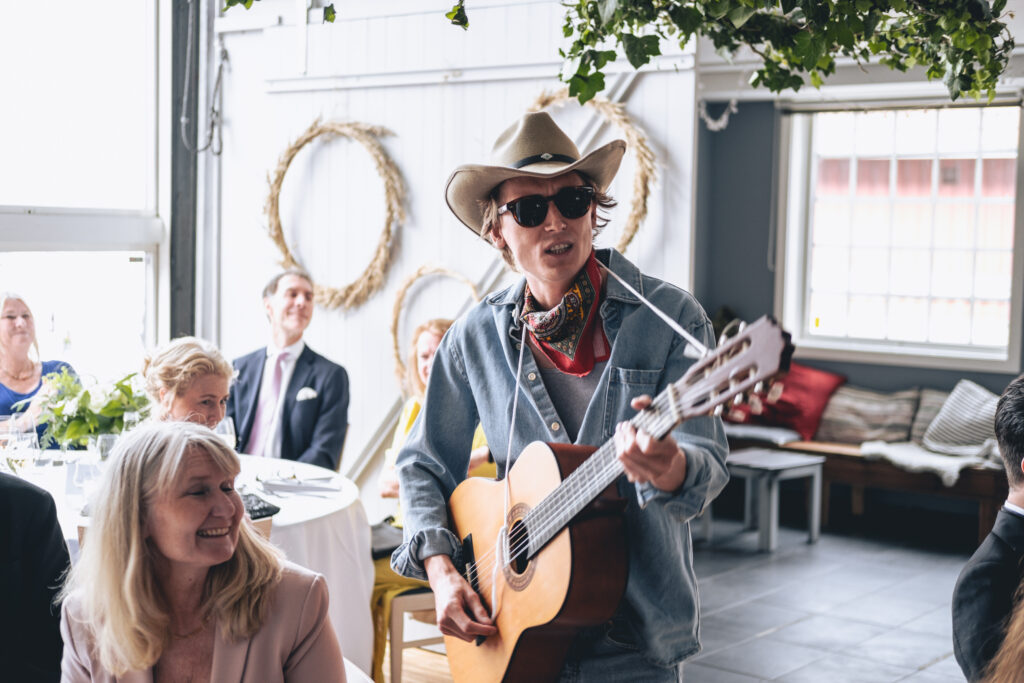 Toastmastern spelar gitarr i cowboy hatt
